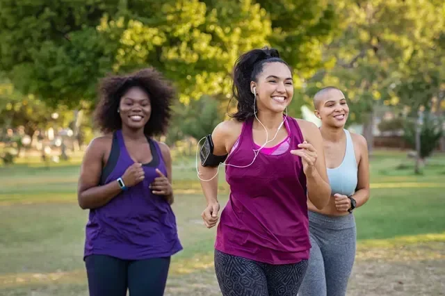 Two active women jogging together outdoors, enjoying the results of a medically guided weight loss plan